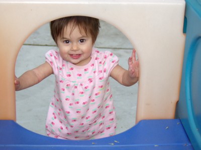 Sophie peeks through a toy slide, October, 2008, Mountain View, CA; photo by Tracee Z.